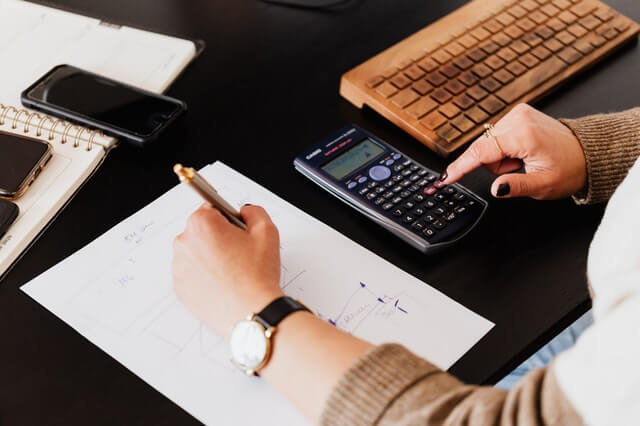 crop woman using calculator and taking notes on paper.jpg